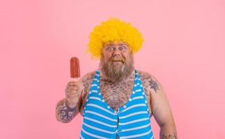 fett förvånad man med skägg och peruk äter en isglass foto