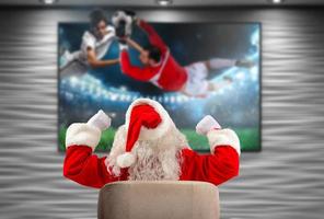 glad santa claus, fotboll fläkt, klockor en spel på tv foto