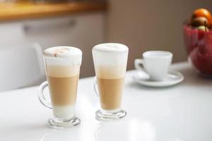 två koppar av latte kaffe på de tabell. morgon- frukost foto
