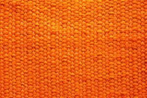 vävd orange ull tyg textur. hand stickat textil- duk bakgrund. patchwork matta bakgrund. fabrik material trådar. abstrakt design. närbild, mockup, topp se foto