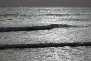 ensam, trångt strand med lugna hav och små vågor foto