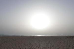 Sol miljö över de hav, solnedgång i höst på de strand av zahara de los atunes, cadiz, andalusien, Spanien foto