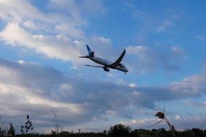 kommersiell flygplan överflygande de himmel och anländer på flygplats foto