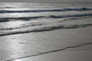 ensam, trångt strand med lugna hav och små vågor foto