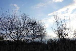 kommersiell flygplan överflygande de himmel och anländer på flygplats foto