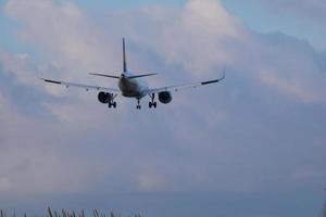 kommersiell flygplan överflygande de himmel och anländer på flygplats foto