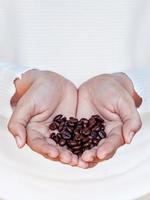 kaffebönor i en kvinnas händer foto