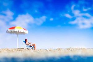 miniatyr människor sola på stranden, sommaren koncept foto
