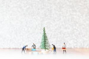 grupp miniatyrarbetare som förbereder ett julgran, julpyntkoncept foto