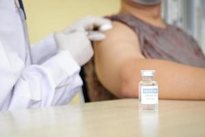 skön asiatisk doktorer vaccinerade coronavirus covid-19 på fet äldre män. begrepp av medicinsk service i de sjukhus. antiviral vaccin foto