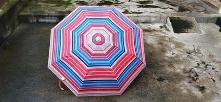 färgrik mönstrad paraplyer i de gård efter regn. regnbåge paraply. naturlig bakgrund. färgrik paraply, symbol av regnig väder säsong. kopia Plats. baner foto