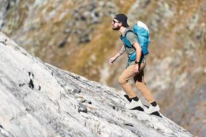 man promenader på klippig backe foto