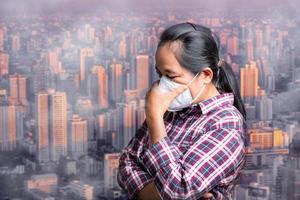 kvinna bär n95 pm 2.5 respiratorisk skydd mask mot luft förorening och damm partiklar överstiga säkerhet gränser. sjukvård, miljö, ekologi begrepp. allergi, huvudvärk. luft fara i stad. foto
