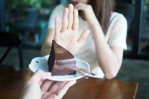 kvinnor vägra till äta trans fett eller choklad kaka för vikt förlust och Bra hälsa. foto