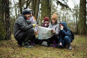 familj och barn med Karta i de skog. foto