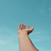 hand upp gestikulerar i de blå himmel, känslor och känslor foto