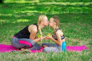 mor kissing henne dotter i de parkera foto