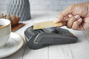kontaktlöst betalningskoncept med ung man som betalar med kreditkort foto