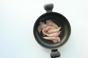rå bröst kyckling kött i en matlagning panorera på vit bakgrund foto