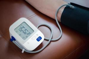 mätning blod tryck på Hem med bärbar enhet, hälsa kolla upp foto