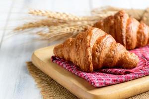 hemlagad croissant på trä tallrik och vit trä bakgrund, bageri foto