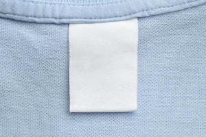 vit tom tvätt vård kläder märka på blå skjorta tyg bakgrund foto