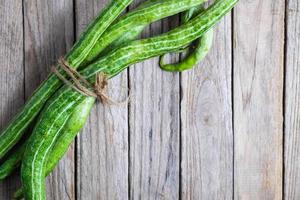 zucchini buntad med garn på träbakgrund foto