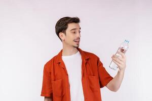 porträtt av Lycklig ung man som visar vatten i en flaska isolerat över vit bakgrund foto