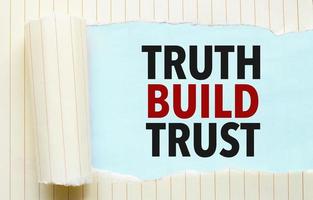 trasig papper med text sanning bygga förtroende och blå bakgrund foto