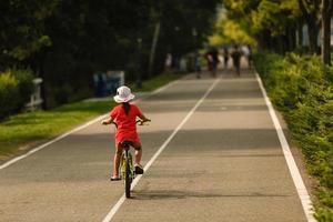 barn som lär sig köra cykel på en uppfart utanför. små flickor cyklar på asfaltvägen i staden foto