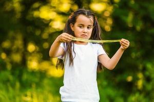 porträtt av en Lycklig leende barn flicka utomhus. söt liten flicka spelar i de parkera foto