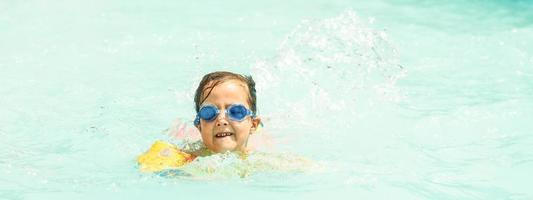 liten flicka är simning i de slå samman. sommar högtider och semester begrepp foto