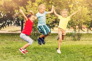 stor grupp av Lycklig glad sportigt barn Hoppar och dans. barndom, frihet, lycka begrepp. foto