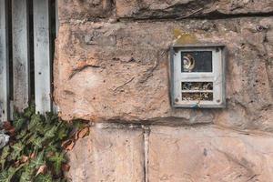 gammal bruten dörrklockan i en sten vägg foto