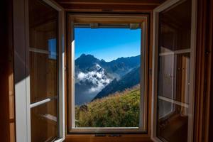 en berg landskap fotograferad från en hus, de fönster former de ram av de bild foto