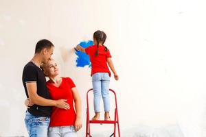 ung Lycklig familj håller på med reparationer i de hus för försäljning. begrepp av hus försäljning. Hem reparera. foto