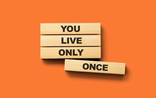 du leva endast en gång yolo text på trä- block isolerat på orange bakgrund, 3d illustration foto