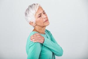 senior kvinna med axel smärta. äldre kvinna är bestående förfärlig värk. axel smärta i ett äldre person. senior lady med axel smärta foto