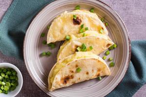 tortillas fylld med mosad potatisar och lök på en tallrik närbild foto