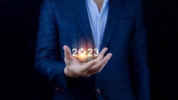företag mål och mål 2023 ikon, hand pekande innehav 2023 virtuell skärm, Start ny år 2023 med en mål planen, verkan planen, strategi, ny år företag syn. foto