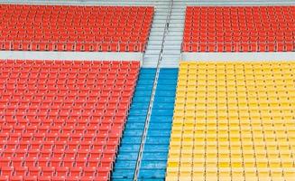 tömma orange och gul säten på stadion, rader av sittplats på en fotboll stadion foto