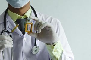 läkare som håller ett covid vaccin foto