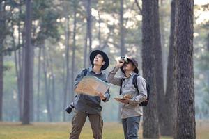 team av de asiatisk naturforskare ser på de Karta medan utforska i de tall skog för undersökande och upptäcka de sällsynt biologisk mångfald och ecologist på de fält studie begrepp foto