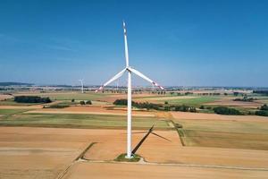 väderkvarn turbin i de fält på sommar dag. roterande vind generator foto
