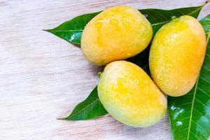 närbild av vilda mango på en trä bakgrund foto
