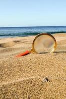 förstorande glas i de sand foto