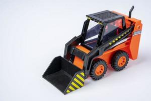 orange leksak lastare på vit bakgrund, mini lastare, leksak industriell bil foto