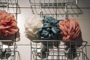 färgrik bad tvättlappar hänga på krokar på de badrum vägg, spa foto