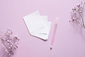 klistermärken för skrivning med en penna på en lila bakgrund Nästa till en vit band och vit blommor foto