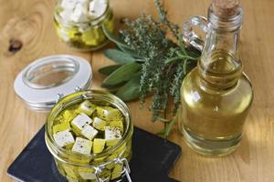 marinerad feta i en glasburk, kryddor och olivolja på träbakgrund foto